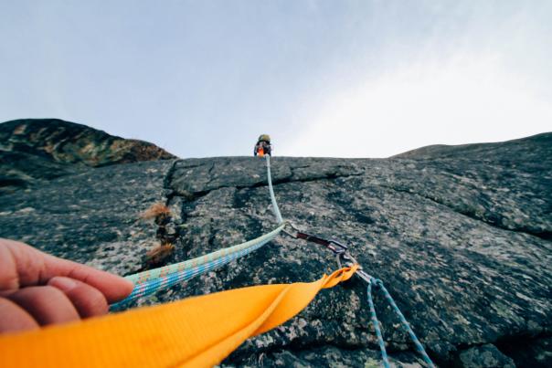 Point of view of repeller of rock climber climbing with rope
