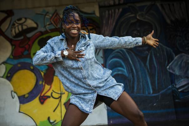 A lady dancing in front of a mural in Columbus, OH