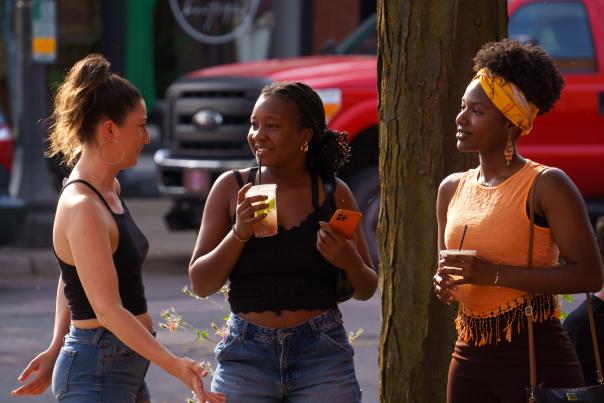 Group of women drinking social district drink in Old Town Lansing at the Arts Night Out event.