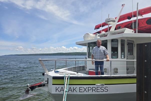 John Madigan on the front of the Kayak Express on Lake Superior with Pictured Rocks Kayaking.