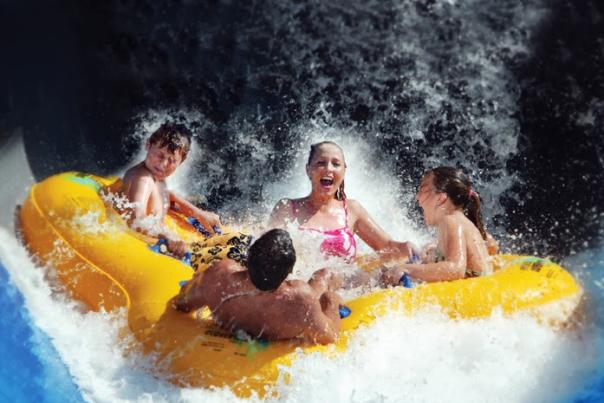 4 people in a large innertube amid waves at JJ's Gold Rush Waterpark