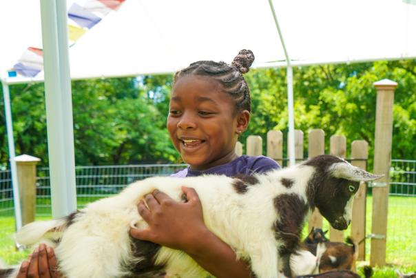 The Traveling Child holding a goat at Providence Hill Farm