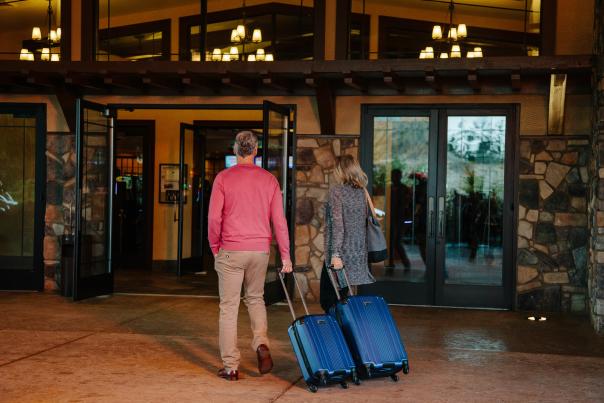 A couple with matching blue luggage enters the lobby at Three Rivers Casino