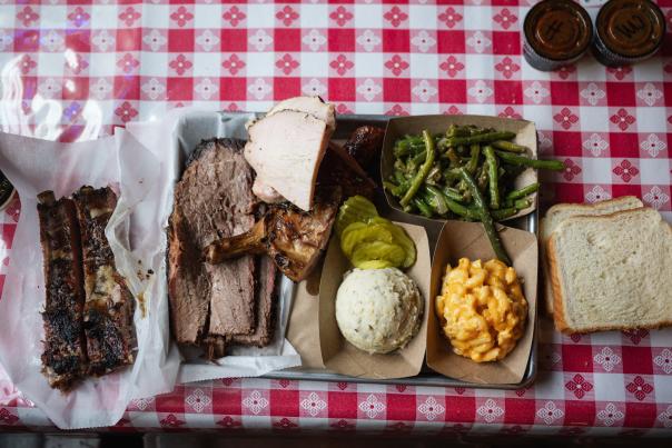 A hefty plate of delicious Texas BBQ adorn a checkered table at Black's BBQ in San Marcos, Texas