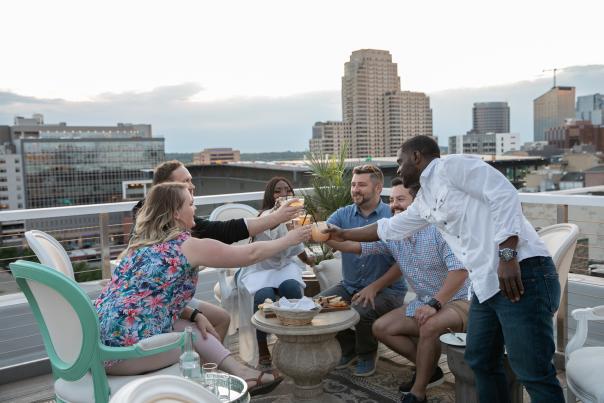 Friends enjoying cocktails and cheers-ing on rooftop