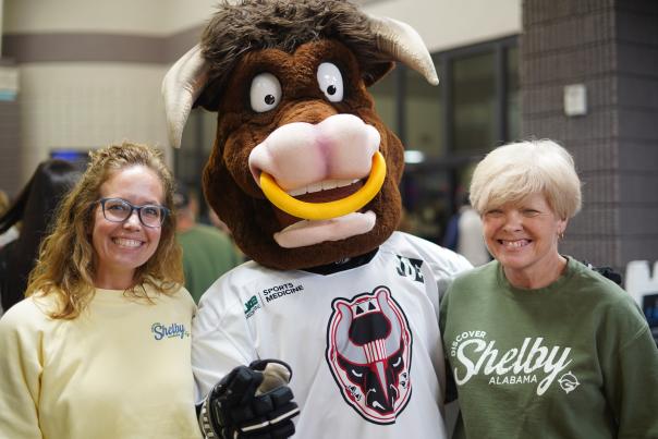 Two people pose with the mascot for the Birmingham Bulls.