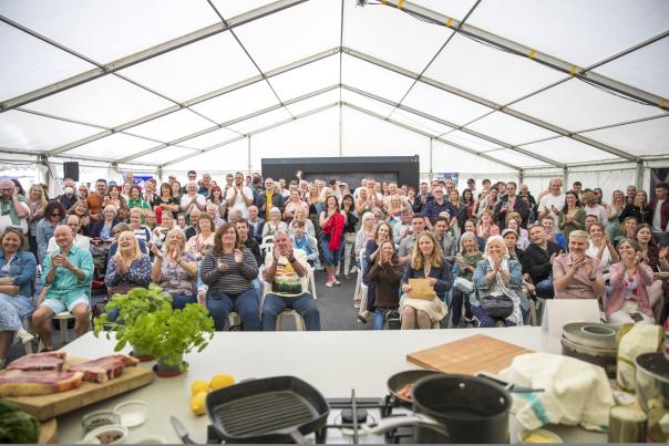 Images shows an audience of men and women at a cookery demo