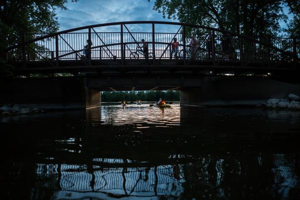 Paddlers enjoying kayaking at nighttime at Riverside Park.