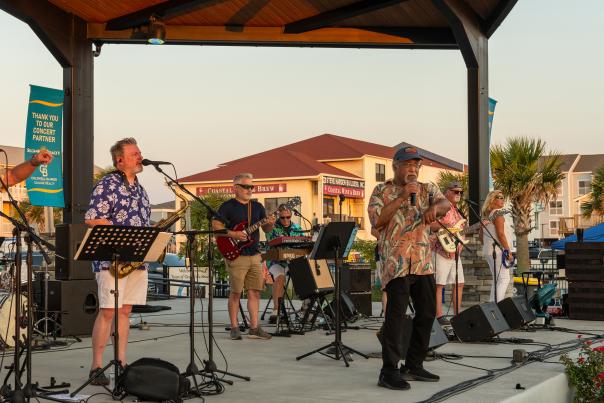 a band on stage at an outdoor concert venue on Ocean Isle Beach