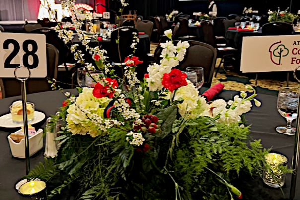 A floral arrangement with reds and whites sits on a table at an event decorated by Epting Events in Athens, GA.
