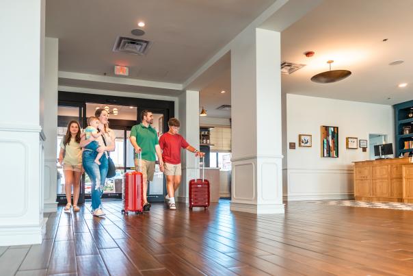 family with suitcases entering a hotel