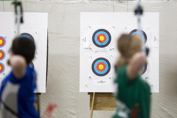 Archers blurred in front with targets in the background.