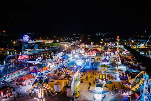 Aerial view of York State Fair at night with glowing rides