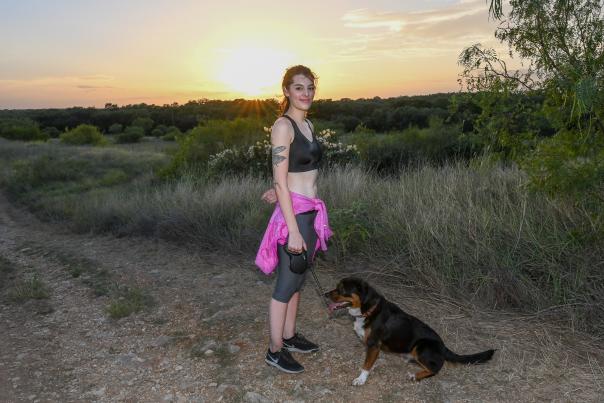 Woman smiling at camera on Purgatory Creek trail with dog