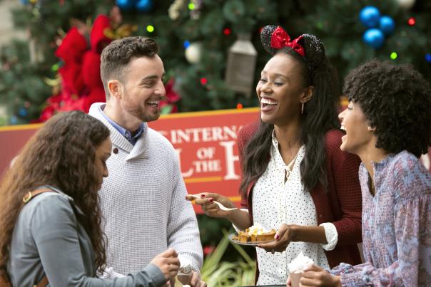 A group of friends eating food and enjoying EPCOT International Festival of the Holidays.