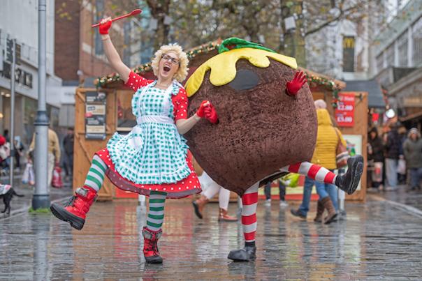 A person in a giant Christmas pudding costume