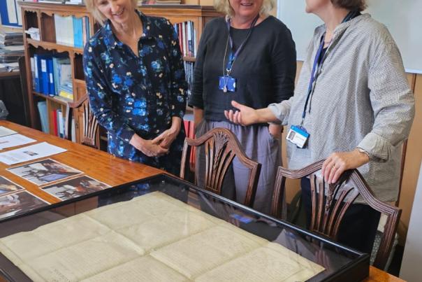 3 women looking at the Declaration held at the records office in a glass case