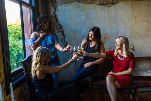 Four women cheering with wine