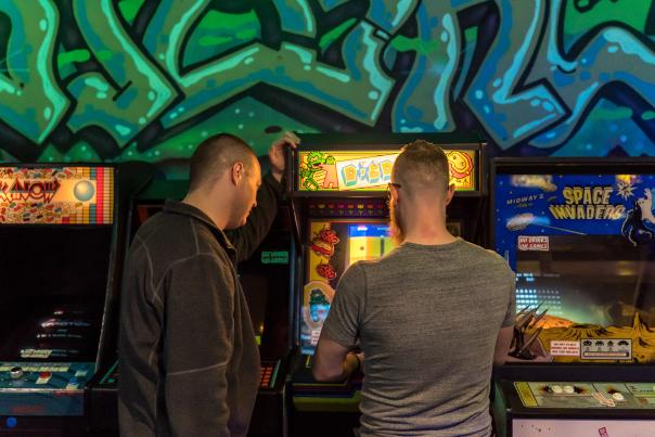 Two guys playing arcade games at Flashback Retropub