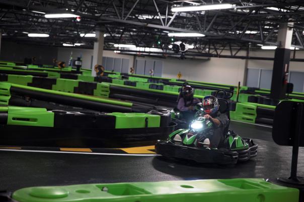 A kart racer zips around a corner at Andretti Indoor Karting & Games