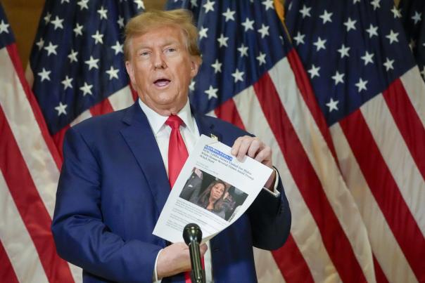 Former President Donald Trump holds up a copy of a story featuring New York Attorney General Letitia James