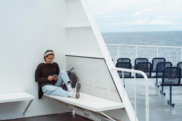 A women sitting outside on the ferry.