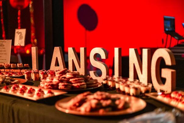 Catering spread and LANSING sign at a reception at Grewal Hall in Lansing.