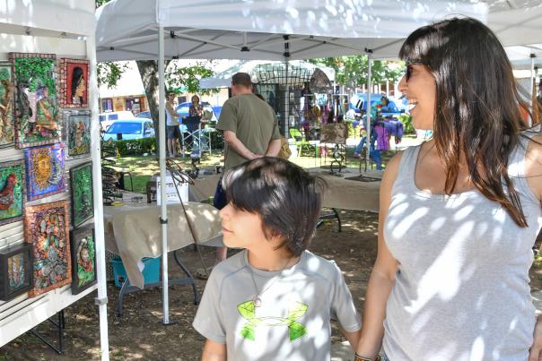 Mom and son looking at booths at art market