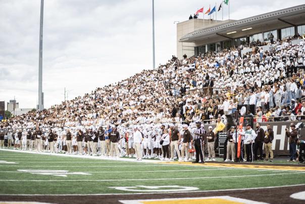 Waldo Football Stadium is filled with Bronco football players and fans in the stands.