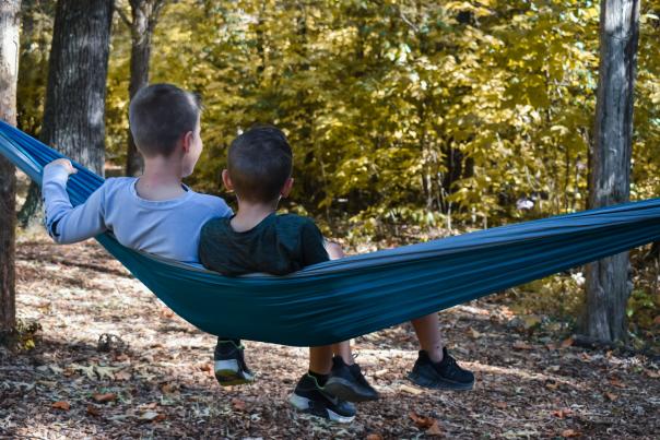 Boys in a hammock in the woods in the Fall