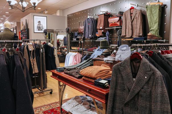 Tables and racks of clothing at Andrew Davis Clothier
