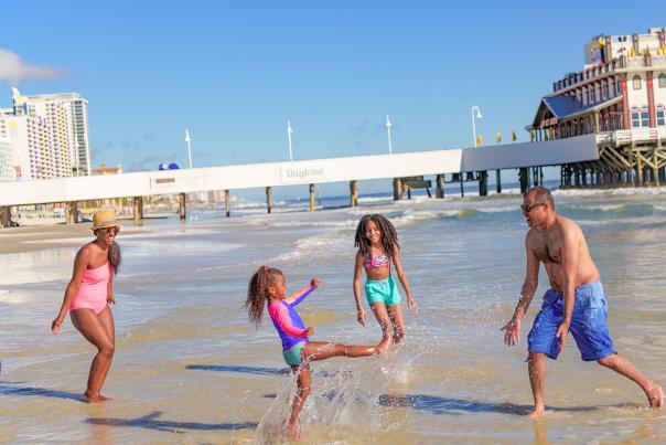 Family playing in the water by the pier