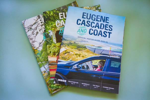 Three visitor guides fanned out with different covers.