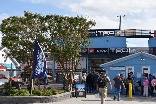 People walking into Georgetown Speedway on sunny day.