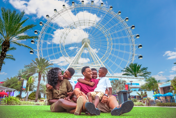 ICON Park family sitting on lawn in front of The Wheel