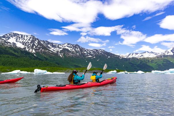 Two people kayaking in front of Spencer Glacier