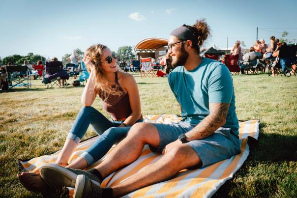 Couple sitting on a blanket at a concert in Festival Country