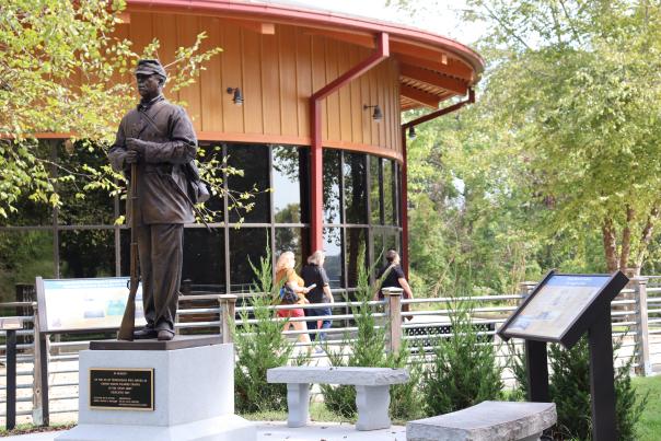statue of an African American soldier beside a visitor center