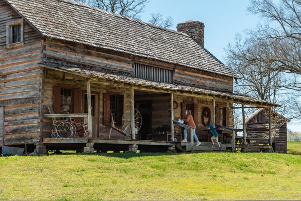 family entering a large historic log home