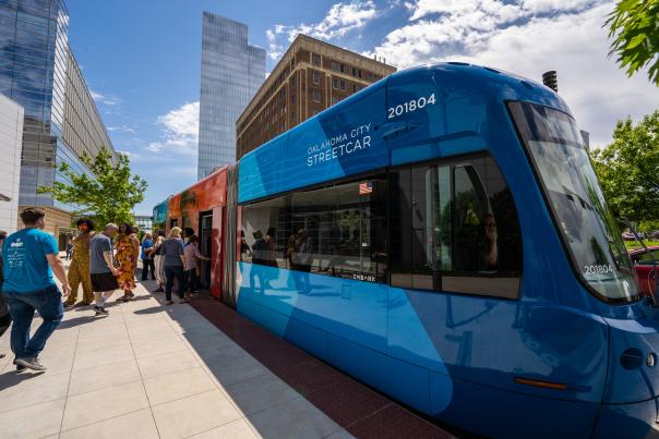 Groups entering and exiting Thunder-themed OKC Streetcar at route stop in downtown Oklahoma City