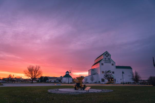 white grain elevator-type building during a purple and pink sunset