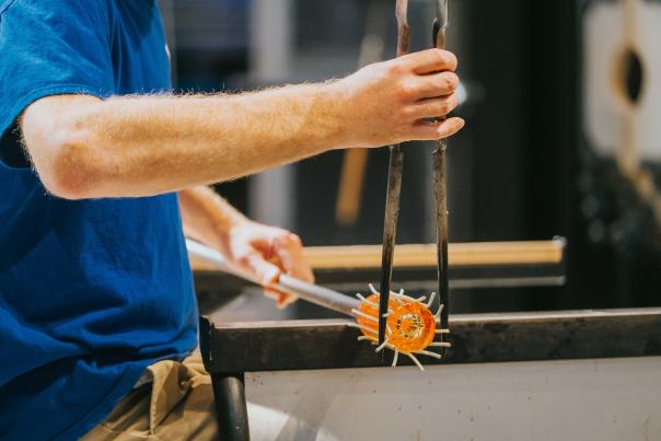 A man works hot glass during a glassblowing demonstration at the Flint Institute of Arts.