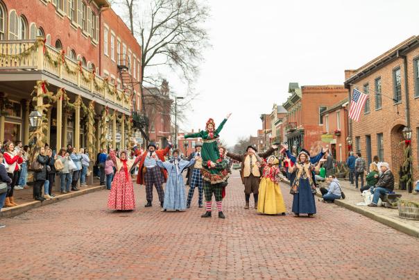 Christmas Traditions street performers in festive costumes entertaining crowd on St. Charles Main Street.