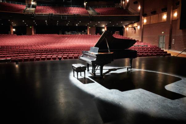 Photo of a piano in an empty theater
