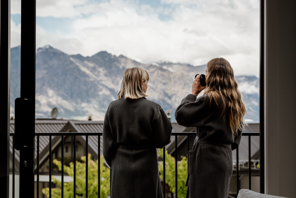 Two women enjoying coffee and view of mountains from their balcony at Kamana Lake House Hotel