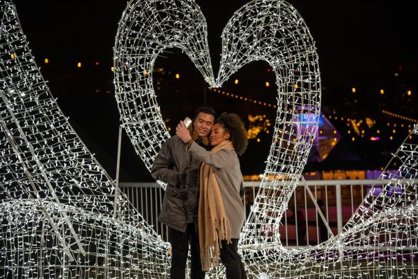 People pose in front of a light display at the Distillery District in Toronto