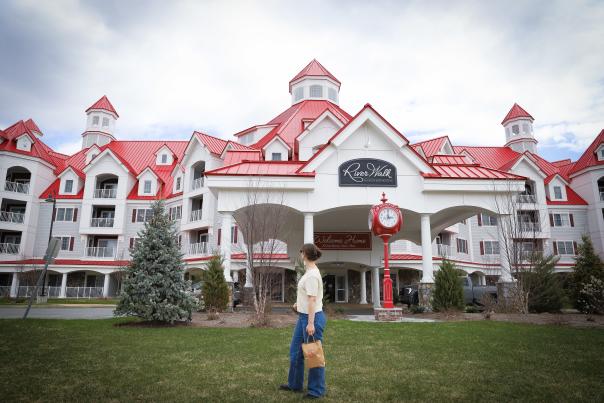 Exterior of RiverWalk Resort at Loon Mountain (Woman Holding Shopping Bag and Looking Up at Building)