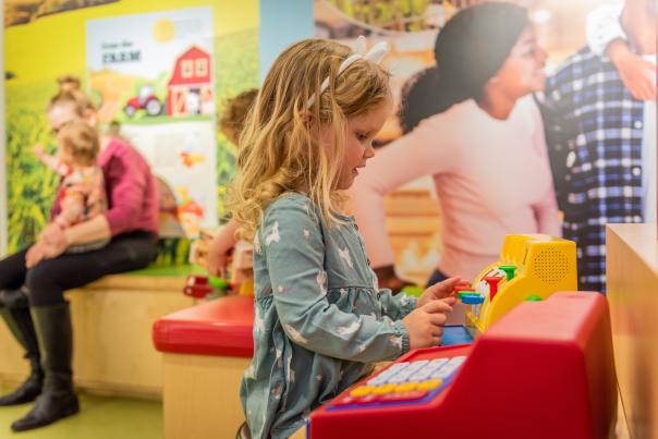 girl playing in a grocery store play area