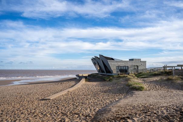 The North Sea Observatory in Chapel St Leonards, blue skies ahead, golden sand on the ground
