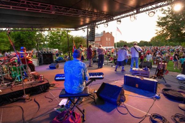 A band of eight plays on stage to a large crowd at the Fort Smith National Historic Site